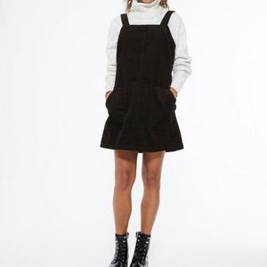 Black corduroy jumper dress with front pockets.